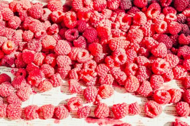 Mavi ahşap bir masa üzerinde bir kutu içinde kırmızı ahududu. Taze çilek. Detoks Diyet ve yaz yiyecek konsepti