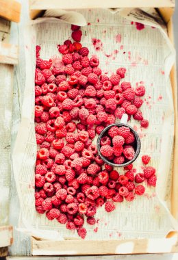 Mavi ahşap bir masa üzerinde bir kutu içinde kırmızı ahududu. Taze çilek. Detoks Diyet ve yaz gıda kavramı. Üstten görünüm.