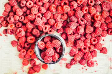 Mavi ahşap bir masa üzerinde bir kutu içinde kırmızı ahududu. Taze çilek. Detoks Diyet ve yaz gıda kavramı. Üstten görünüm.