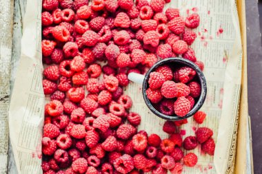 Mavi ahşap bir masa üzerinde bir kutu içinde kırmızı ahududu. Taze çilek. Detoks Diyet ve yaz gıda kavramı. Üstten görünüm.