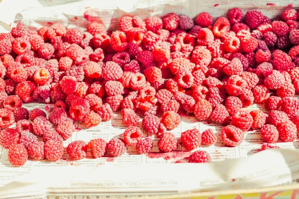 Mavi ahşap bir masa üzerinde bir kutu içinde kırmızı ahududu. Taze çilek. Detoks Diyet ve yaz yiyecek konsepti