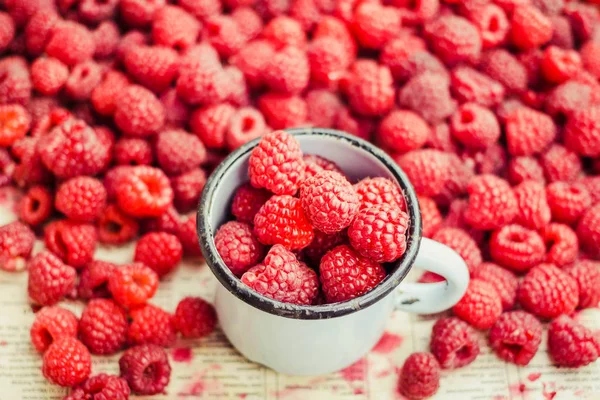 Mavi ahşap bir masa üzerinde bir kutu içinde kırmızı ahududu. Taze çilek yığını. Detoks Diyet ve yaz gıda kavramı. Portre.