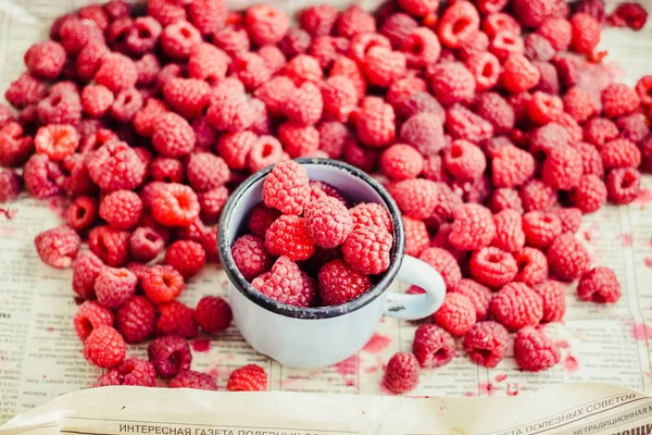 Red raspberries in a box on a blue wooden table. Fresh berries.Detox diet and summer food concept.Closeup.