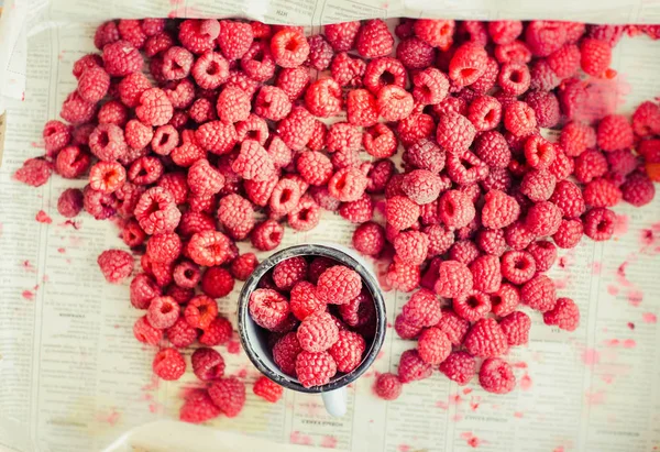 Red raspberries in a box on a blue wooden table. Fresh berries.Detox diet and summer food concept.Top view.