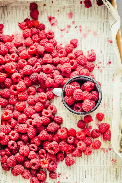 Mavi ahşap bir masa üzerinde bir kutu içinde kırmızı ahududu. Taze çilek. Detoks Diyet ve yaz yemek concepttop görünümü.
