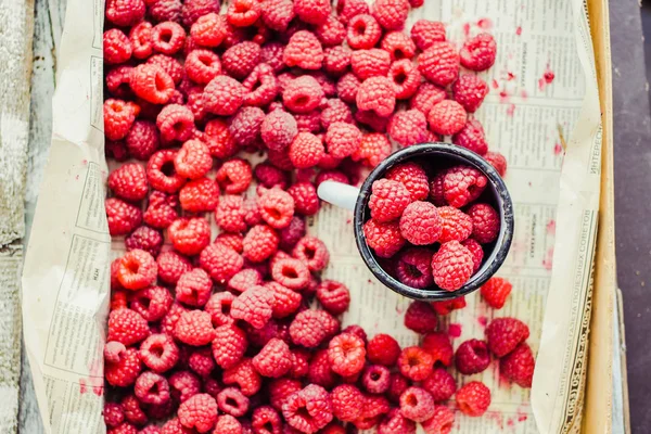 Mavi ahşap bir masa üzerinde bir kutu içinde kırmızı ahududu. Taze çilek. Detoks Diyet ve yaz gıda kavramı. Üstten görünüm.