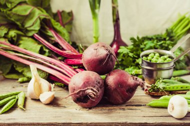 Organik genç pancar, Yeşiller, sarımsak ahşap arka plan üzerinde. Sonbahar taze sebze. Seçici odak.