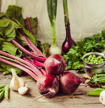 Organik genç pancar, Yeşiller, sarımsak ahşap arka plan üzerinde. Sonbahar taze sebze. Seçici odak. Tonlama. Insta-boyut.