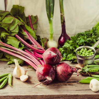 Organik genç pancar, Yeşiller, sarımsak ahşap arka plan üzerinde. Sonbahar taze sebze. Sağlıklı ve ham antioksidan gıda kavramı.