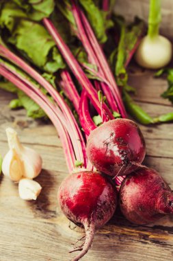 Organik genç pancar, Yeşiller, sarımsak ahşap arka plan üzerinde. Sonbahar taze sebze. Seçici odak.