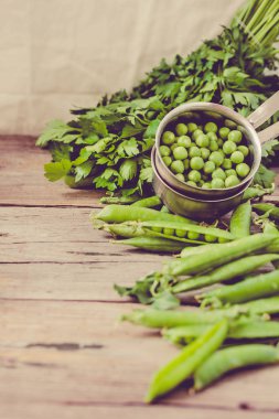 Ahşap arka plan üzerinde taze genç organik bezelye. Seçici odak. Sağlıklı ve dengeli gıda kavramı. Metin için yer. Zil sesi.
