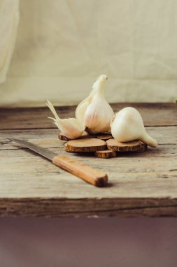 Gri bir ahşap zemin üzerine taze genç organik sarımsak. Seçici odak. Sonbahar taze sebze