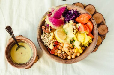 Bir dengeli öğle/akşam yemeği - çok renkli sebze, baharatlı fasulye (nohut), kurutulmuş domates, limon, fındık, kimchi zerdeçal ahşap yemekler ile