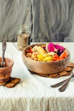 Sağlıklı yemek - sebze, baharatlı nohut, havuç, daikon turp, kırmızı lahana, kimchi zerdeçal kaju fıstığı sosu ahşap yemekler ile