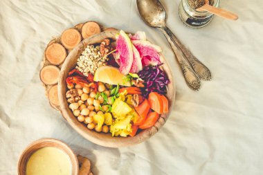 Dengeli bir yemek - çok renkli sebze, fasulye (nohut), kurutulmuş domates, limon, fındık, kimchi zerdeçal ahşap yemekleri ile. Üstten görünüm. Tonlama.