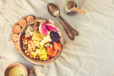 Bir dengeli öğle/akşam yemeği - çok renkli sebze, baharatlı fasulye (nohut), kurutulmuş domates, limon, fındık, kimchi zerdeçal ahşap yemekler ile