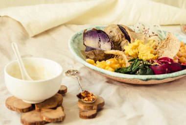 Vegan detoks öğle mor patates, haşlanmış ıspanak ve humus Mısır kraker ile.