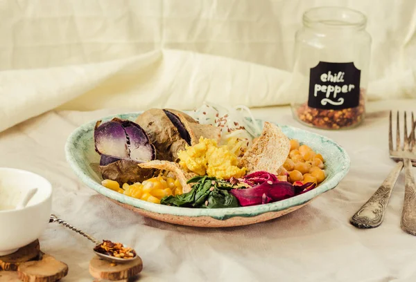 Vegan detoks öğle mor patates, haşlanmış ıspanak ve humus Mısır kraker ile.