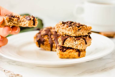 Organik müsli ve kurutulmuş meyve çubukları. Sağlıklı kahvaltı ve snack. Beyaz masa arka plan... Yeme işlemi. Genç bir kadın elinde. Zil sesi.