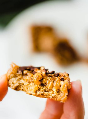 Çiğ vegan kek Çikolata, beyaz bir kase dilimlenmiş parçaları yığını ile. Dietic tatlı. Sağlıklı vegan gıda kavramı. Yeme işlemi. Genç bir kadın elinde. Metin için yer.