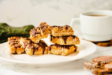 Raw Paleo energy bars made with healthy nuts and dried fruits. Homemade Snack on a white marble table. Diet detox food concept.Sugar free.