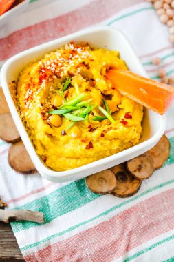 Humus veya houmous, iştah tahin, limon, sarımsak, zeytinyağı, maydanoz ve kırmızı biber ile ahşap masada nohut püresi yapılmış.