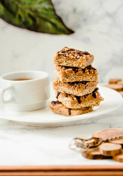 Raw vegan dessert with oats, nuts and dates on a white marble table. Healthy lifestyle and raw vegan dessert concept.