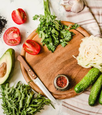 Yeşillik, domates, salatalık, baharat, avokado, sebze, bahar taze yiyecek. Ham salata hazırlanıyor. Ahşap tahta. Vejetaryen ve vegan gıda kavramı. Instagram boyutu.