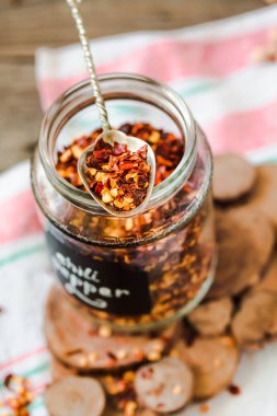 Biber pul yazıt ile bir cam kavanoza sıcak. Rustik arka plan.