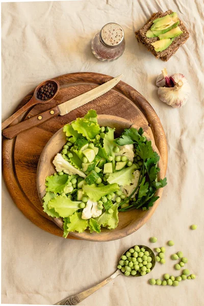 Čerstvý lahodný zelený salát s avokádem v dřevěné desky a g — Stock fotografie