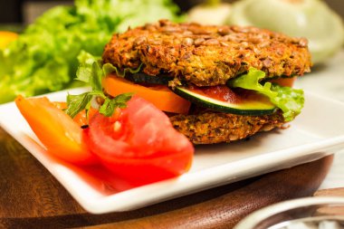 Fasulye ve tohumlar, sebzeler ve otlar ile pişmiş Vegan burgerler. 