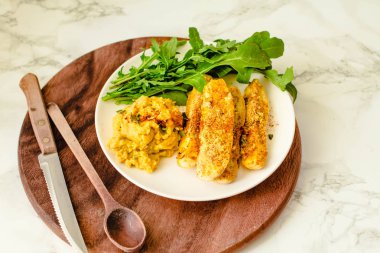 Humus ve roka ile gevrek meyilli pişmiş kabak çubukları. 