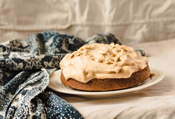 Chocolate cake with banana mousse cream icing with peanuts. On w — Stock Photo, Image