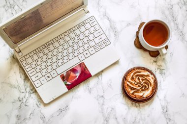 Beyaz mermer üzerinde kadın elleri yukarıdan görünümü bir fincan çay tutun