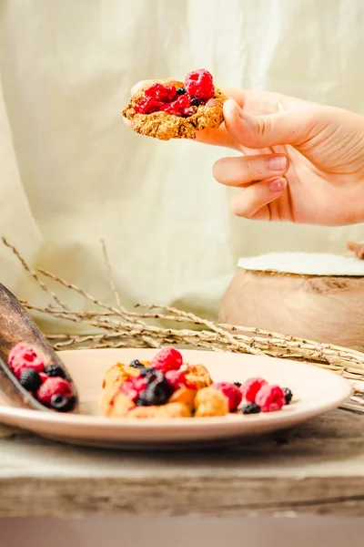 Biscuits à l'avoine avec confiture de framboises et caramel aux dattes dans les mains — Photo