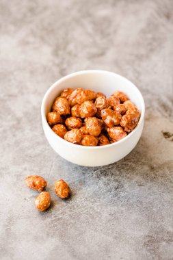 Beyaz kase ve gri arka planda şeker fıstık. Seçici