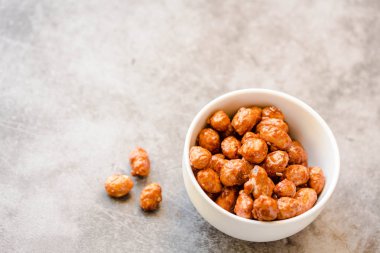 Beyaz kase ve gri arka planda şeker fıstık. Horizonta