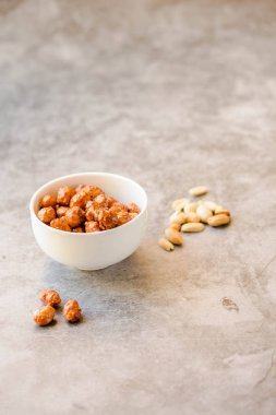 Beyaz kase ve gri arka planda şeker fıstık. Seçici