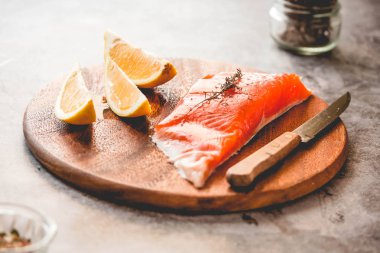 Çiğ somon fileto biber tuz dereotu limon ve biberiye bir ahşap