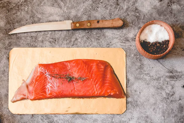 Raw salmon filet on gold board and gray slate background, wild a