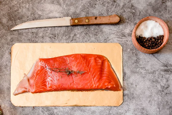 Raw salmon filet on gold board and gray slate background, wild a