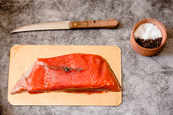 Raw salmon filet on gold board and gray slate background, wild a — Stock Photo, Image