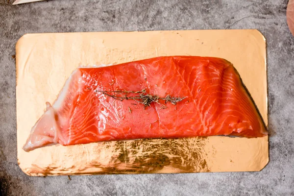 Raw salmon filet on gold board and gray slate background, wild a