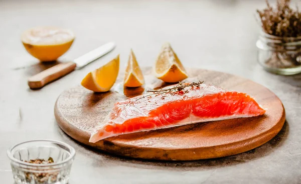 Raw salmon fish filet with lemon and spices. On a wooden backgro — Stock Photo, Image