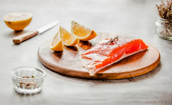 Raw salmon fish filet with lemon and spices. On a wooden backgro — Stock Photo, Image