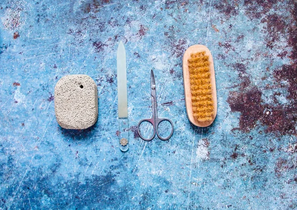 Pozor na nehty. Skleněný nehet, dřevěný kartáč, kovové nůžky na modré — Stock fotografie