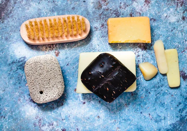 Barra de jabón diferente en un plato de jabón de cerámica sobre un fondo azul . —  Fotos de Stock