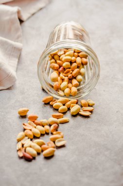 Gri arka planda bir bardakta kavrulmuş fıstık. Sağlıklı lifesty