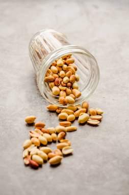 Gri arka planda bir bardakta kavrulmuş fıstık. Sağlıklı lifesty