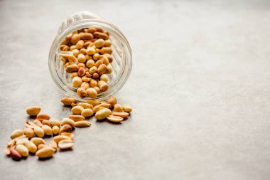 Gri arka planda bir bardakta kavrulmuş fıstık. Sağlıklı lifesty